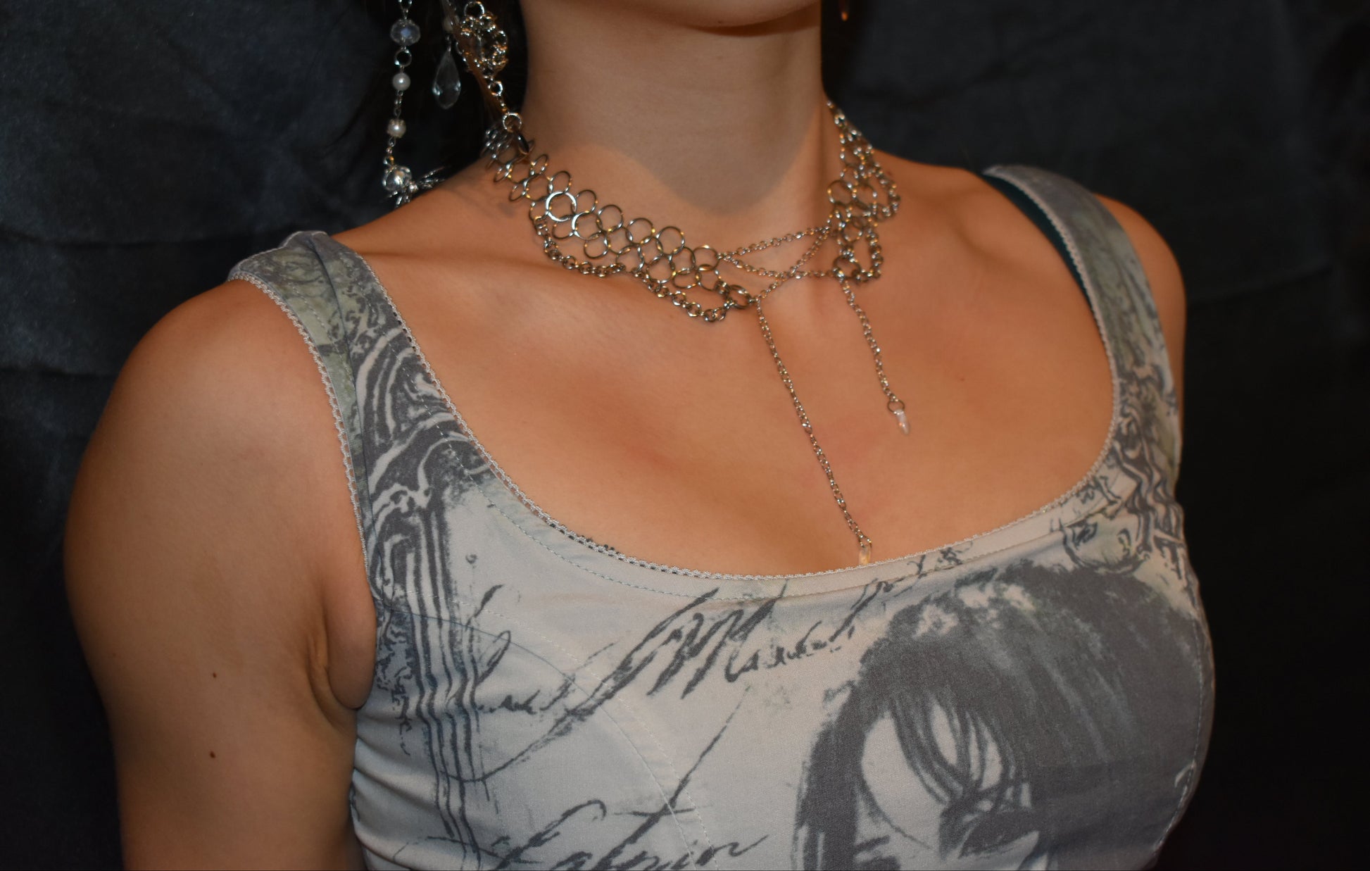 Close-up of a person wearing multiple necklaces with a dark background
