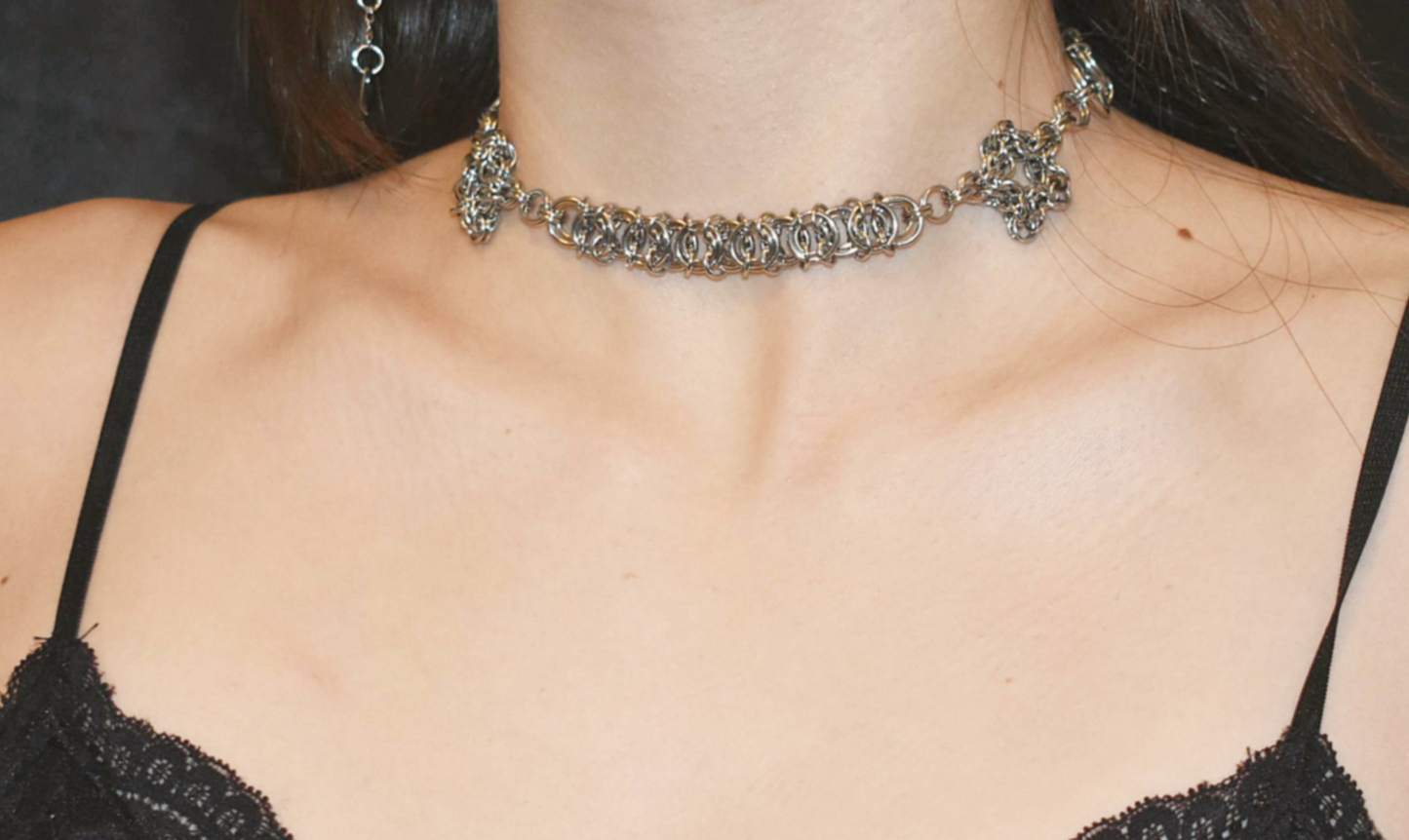 Close-up of a person wearing a decorative necklace with a black top.