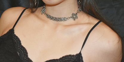 Person wearing a black lace top and silver necklace
