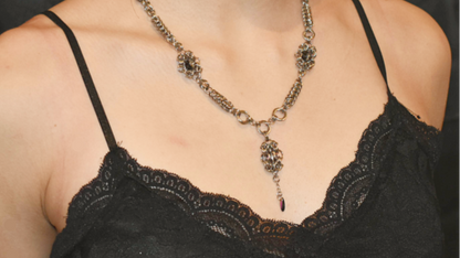Black lace top with a detailed necklace on a person