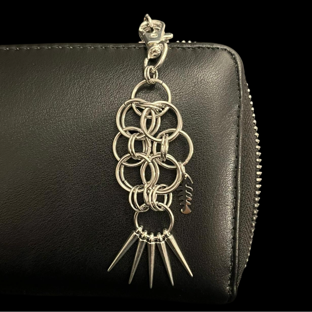 Black leather wallet with a silver chain and spike design on a black background