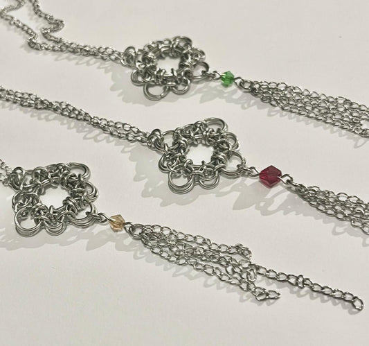 Silver chain necklace with floral designs and beads on a white background