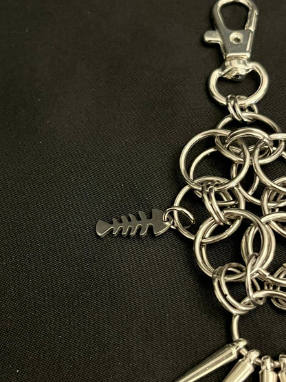 Silver chain keychain with a fish bone charm on a black background