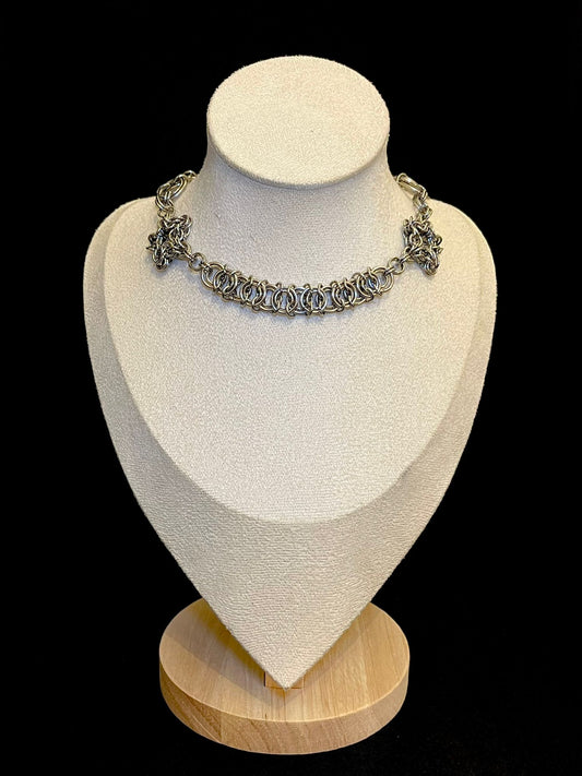 Necklace displayed on a mannequin bust with a black background