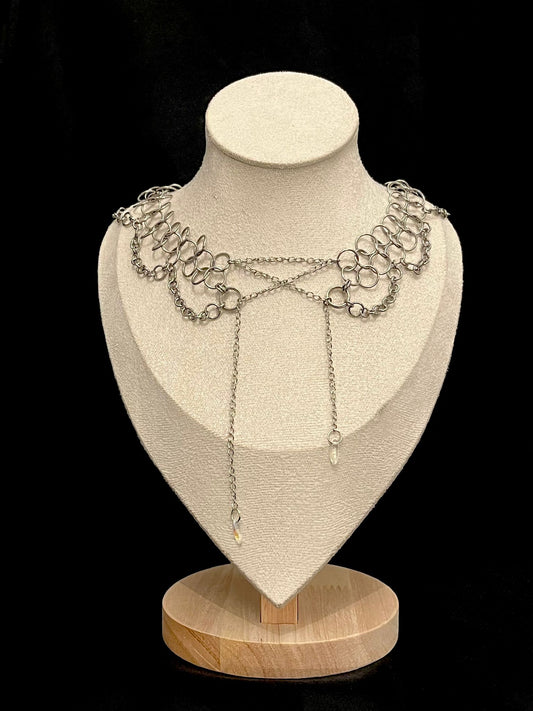 Silver corset alternative style necklace displayed on a mannequin bust with a black background