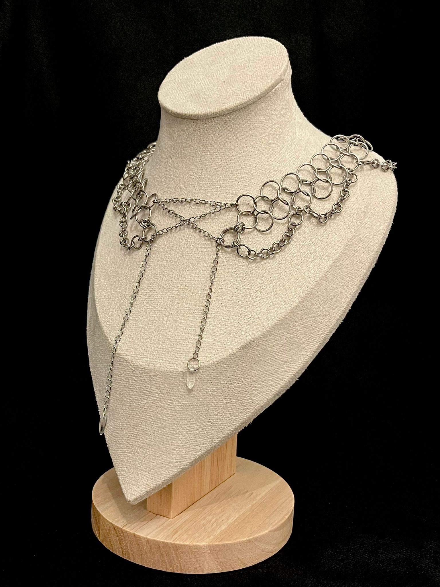 Necklace displayed on a mannequin bust with a black background
