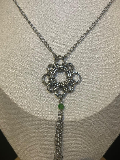 Silver necklace with a decorative pendant on a mannequin bust.