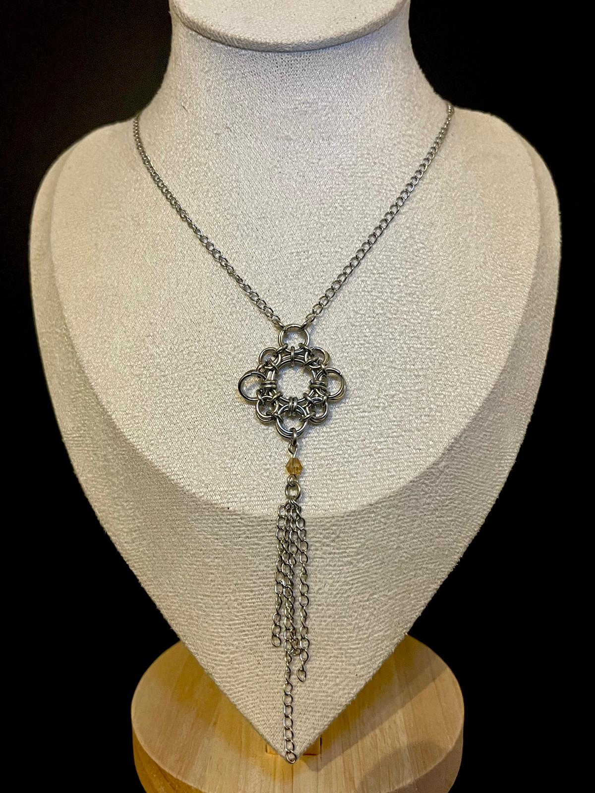 Necklace with a floral pendant on a mannequin bust against a black background