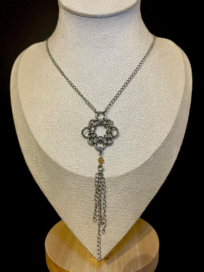 Necklace with a floral pendant on a mannequin bust against a black background
