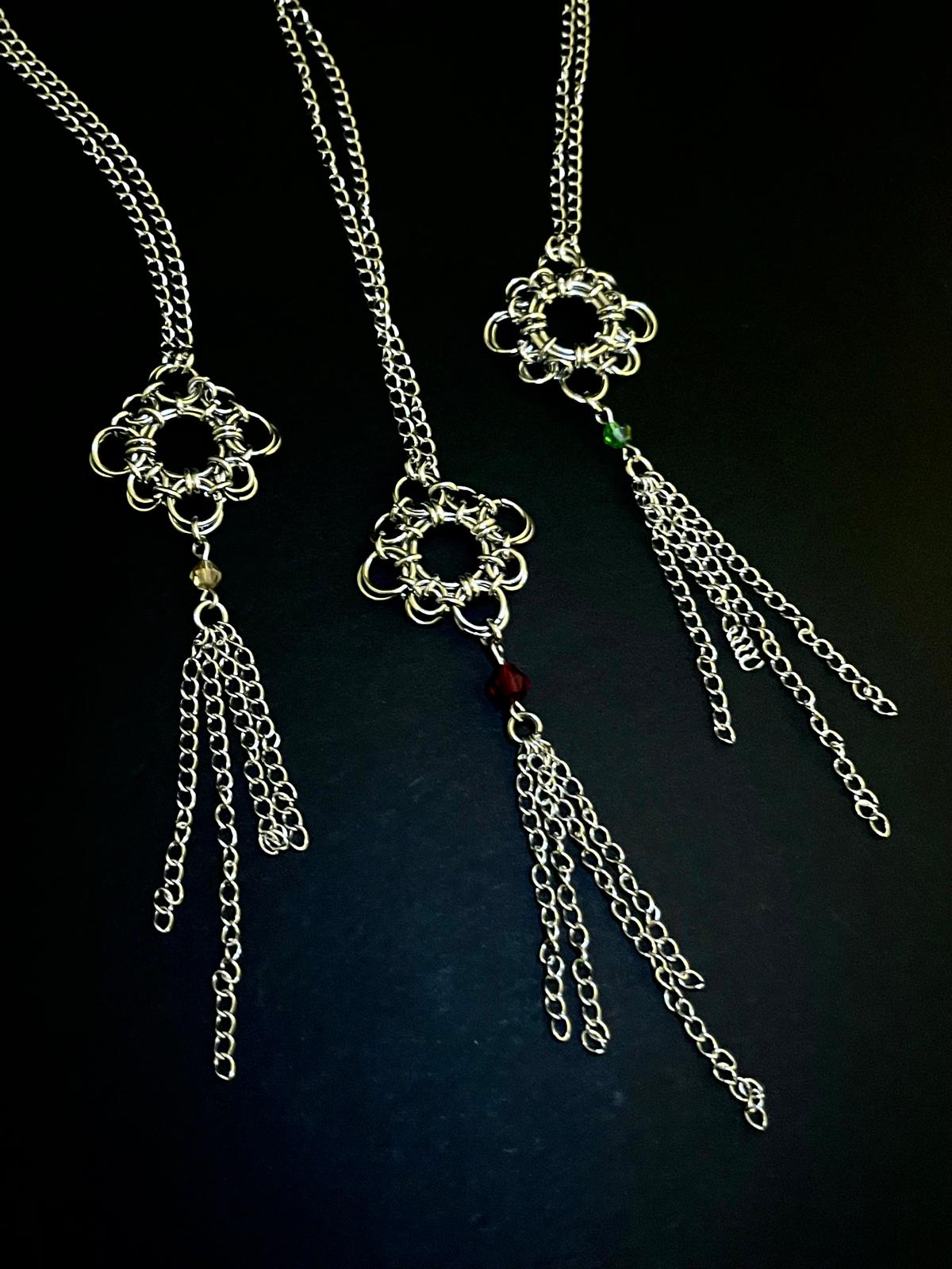 Silver chain necklace with floral pendant on a dark background