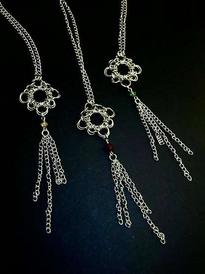 Silver chain necklace with floral pendant on a dark background