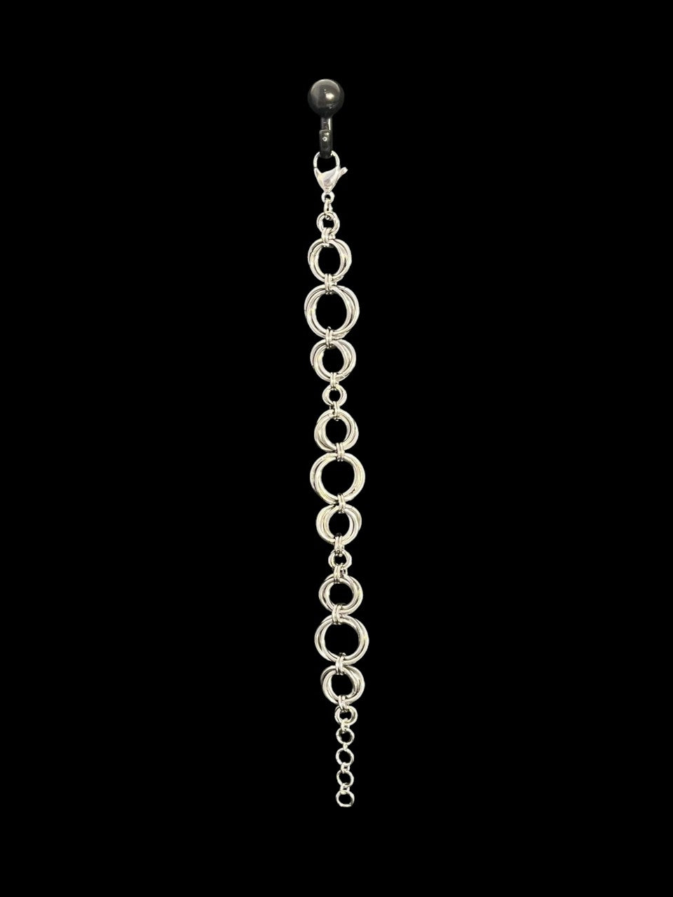 Silver chain earring on a black background