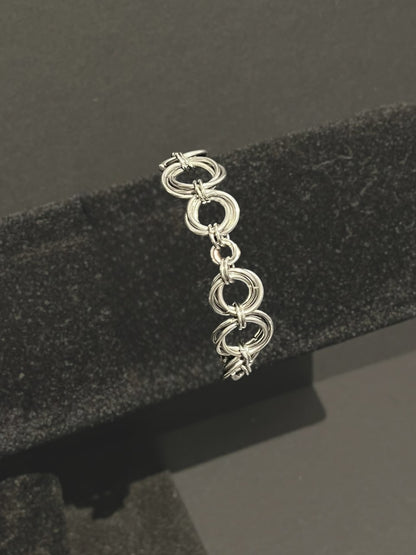 Silver bracelet on a black textured stand