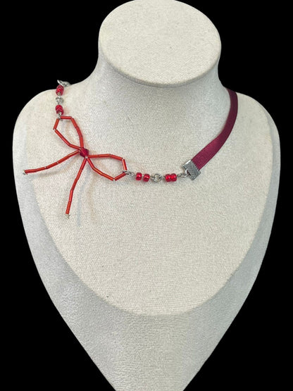 Necklace with red and silver design on a white mannequin bust